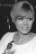 Working behind the bar, Wendy Richard pours a drink