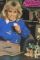 Wendy Richard, dressed in jeans and a blue sweatshirt, sits surrounded by her frog
				 collection