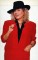 Wendy Richard poses in a red tunic and black fedora