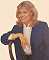 Wendy Richard sitting on a chair
