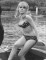 Wendy Richard, wearing a bikini, stands in a motorboat