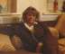 Wendy Richard, dressed in a brown tracksuit, sitting on the sofa in her flat, 
				  circa 1989.