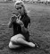 Wendy Richard sitting in a grassy square, sometime in 1969.