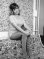 Coy Wendy Richard sitting with hands clasped over knees, wearing knee boots, hot pants, and open-necked blouse, circa 1971