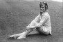 Wendy Richard reclining on grass, wearing a blue and white striped shirt - 1972