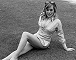 Wendy Richard reclining on grass, wearing a blue and white striped shirt - 1972