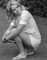 26-year-old Wendy Richard crouches on the lawn in a London park
